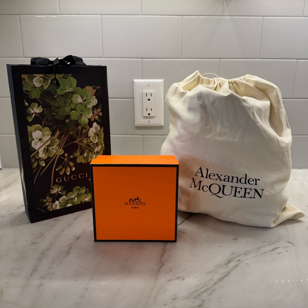 Hermes Vibrant Orange Decorative Box, Gucci showing bag, Alexander McQueen dust